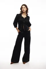 Blusa marrón de lino liviano con escote en V, abotonadura frontal y mangas 3/4 con puño. Diseño con frunces que generan un efecto entallado en la parte superior y amplio en el ruedo.