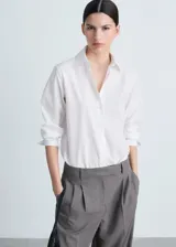 Camisa blanca de popelina de algodón y lyocell, corte recto, manga larga con puños abotonados y cuello camisero.