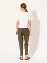 Pantalón babucha color verde militar, confeccionado en tejido de punto y plano. Tiene cintura elastizada con cordón ajustable y largo al tobillo.