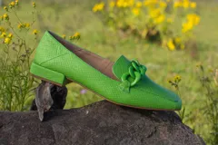 Mocasines verdes con textura símil piel de reptil y detalle de cadena plástica en el empeine.