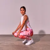 Musculosa deportiva blanca de corte holgado, con sisas amplias y logo pequeño estampado en el ruedo.