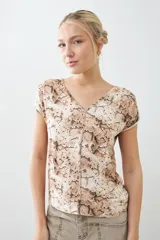 Blusa beige con estampado animal print, escote en V y mangas cortas.