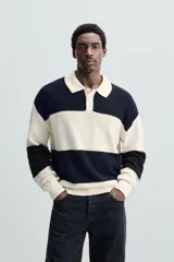Sweater tipo polo de punto con rayas horizontales anchas en color negro y crudo, con cuello clásico y cierre de dos botones.
