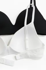 Pack de dos soutiens de microfibra, uno blanco y otro negro, sin aros, con copas acolchadas, breteles ajustables y cierre de corchetes en la espalda.