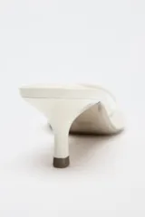 Sandalia tipo mule de charol color blanco, con tira delantera y tacón fino medio.