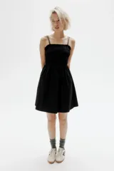 Vestido corto negro de algodón con cuerpo fruncido, escote cuadrado y breteles spaghetti dobles.