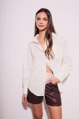 Camisa oversize color crudo, confeccionada en lino y viscosa, con cuello clásico, cierre frontal con botones de nácar y manga larga.