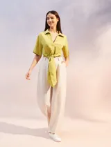 Camisa color verde lima con textura arrugada, corte holgado, mangas cortas y lazo para atar en la parte delantera.