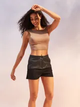 Short negro de tiro alto con efecto cuero en la parte superior y tela de sarga o similar en la parte inferior. Presenta un botón frontal y bolsillos laterales.