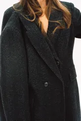 Abrigo largo de Zara Woman Collection confeccionado en tejido con 30% lana. Tiene cuello solapa de muescas, manga larga con abertura y botones, bolsillos con solapa en el delantero y de vivo en el pecho. Forro interior a tono y cierre frontal cruzado con botones.