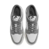 Championes Nike Dunk Bajo Retro SE, color gris y blanco, con detalles en marrón en la suela.