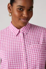Camisa de manga corta con estampado a cuadros rosa y blanco, cuello clásico y cierre frontal con botones.