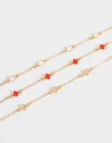 Set de tres pulseras doradas con dijes de flores de metal y resina.