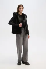 Chaleco marrón de piel sintética con capucha y cierre frontal con cremallera.