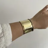 Brazalete ancho de bronce, ajustable, con bordes redondeados.