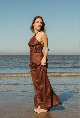 Pantalón marrón de lino, de tiro alto y corte palazzo con aberturas laterales en el ruedo.