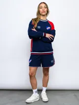 Short deportivo azul marino con ribetes blancos y rojos, y escudo del Club Nacional de Football bordado en la pierna derecha.