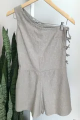 Mono corto color beige de lino y algodón, con un solo tirante y ajuste lateral con lazos.