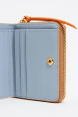 Monedero Bimba y Lola color naranja con textura granulada, logo dorado estampado, cierre de cremallera dorada y tarjetero interior.