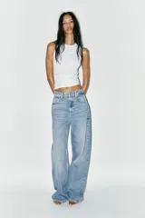 Pantalón de jean celeste de corte extra wide leg, tiro alto, cinco bolsillos, trabillas en la cintura y cierre con cremallera y botón metálico.