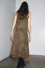 Vestido midi de viscosa con estampado animal print, cuello halter ajustable con lazos en la espalda y bajo asimétrico.