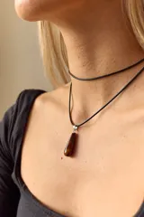 Gargantilla doble con choker de cuero negro y collar con dije de piedra natural marrón en forma de gota con engarce de acero quirúrgico hipoalergénico y tiento negro.