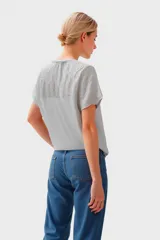 Remera gris con detalle de bordado calado en cuello y mangas cortas.