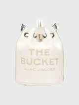 Bolso tipo bucket de cuero color gris con logo "The Bucket Marc Jacobs" estampado en negro. Tiene asa corta de cuerda trenzada y correa larga de cuero ajustable y removible.