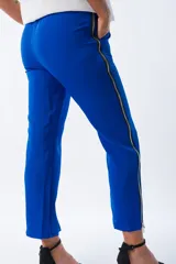 Pantalón azul eléctrico de corte cigarette, con bolsillos laterales y cierre lateral con cremallera plateada desde el tobillo hasta la cintura.