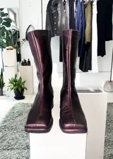 Bota de cuero negra, de caña media, punta cuadrada y taco bajo forrado.