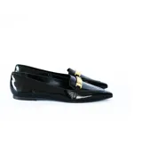 Mocasín negro de charol con punta fina y aplique metálico dorado en el empeine.