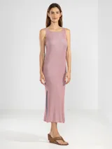 Vestido largo tejido en jersey con hilo lurex dorado, de corte recto, escote bote y aberturas laterales.