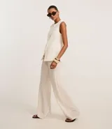 Pantalón wide leg color beige con textura, cintura elástica con cordón ajustable y bolsillos laterales.