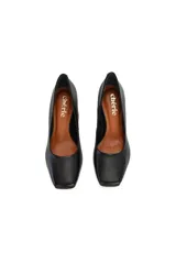 Zapatos de tacón negros con punta cuadrada y tacón geométrico de madera.