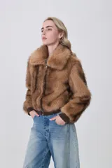 Campera de piel sintética color tostado con cuello clásico, cierre frontal de cremallera y terminaciones elásticas en puños y cintura.