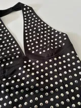 Top negro con escote halter y estampado de lunares plateados.