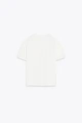 Camiseta blanca de algodón de manga corta y cuello redondo con detalle de flores en relieve en el frente.