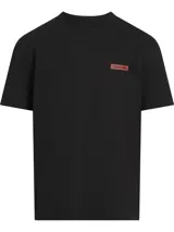 Remera negra de corte relaxed, cuello redondo y manga corta. Presenta un parche con el logo de Calvin Klein en el pecho.