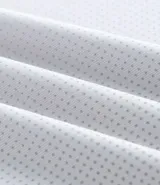 Remera deportiva gris de poliéster con cuello redondo y mangas cortas. Presenta un diseño degradado en el frente y protección UV.