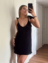 Vestido corto tejido en algodón y lurex color verde militar, con escote en la espalda y tiras con borlas que regulan el largo.