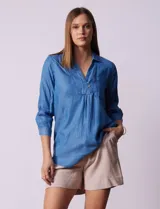 Blusa celeste de lyocell con cuello camisero, escote en V con botones, mangas 3/4 con puño y bolsillo en el pecho.