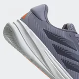 Championes de running Adidas Supernova Ease color gris con detalles en azul y negro. Presentan las tres tiras características de la marca en los laterales y suela blanca con tecnología Dreamstrike.
