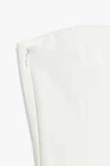 Top palabra de honor blanco con hombros descubiertos, corte ajustado y bajo con peplum.