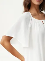 Blusa blanca de mangas cortas con escote redondo y lazos.