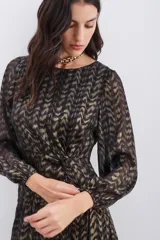 Vestido corto negro con estampado dorado, escote redondo, mangas largas con elástico en los puños, detalle de nudo drapeado en la cintura, escote en V pronunciado en la espalda, cinta elástica en la espalda y cierre invisible.