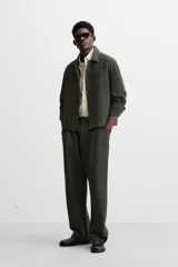 Sobrecamisa verde oscuro de corte cuadrado, con cuello solapa, manga larga con puños abotonados, bolsillos de parche en el pecho y bolsillos laterales en la cadera. Cierre frontal con botones.