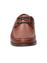 Zapato náutico de cuero marrón con cordones negros, suela de goma y detalle de logo de pato bordado en el lateral.