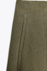 Pantalón color crema de lino, de tiro alto, corte recto y bolsillos delanteros.