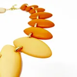 Collar corto con eslabones dorados y piezas de resina color marfil con forma de hojas. Cierre con mosquetón y largo regulable.