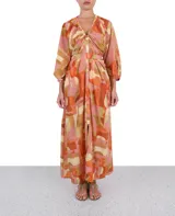 Vestido largo de poliéster con estampado abstracto en tonos rosa, naranja, beige y marrón. Tiene escote en V, mangas 3/4 abullonadas y lazo en la cintura.